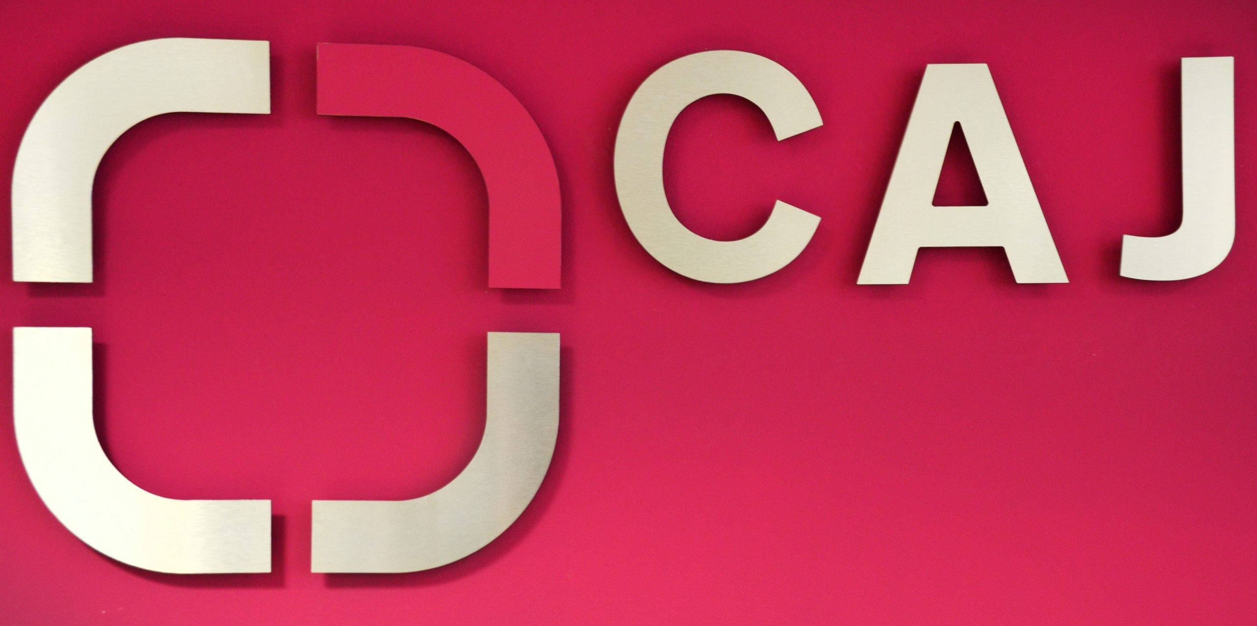 caj logo pink wall CAJ